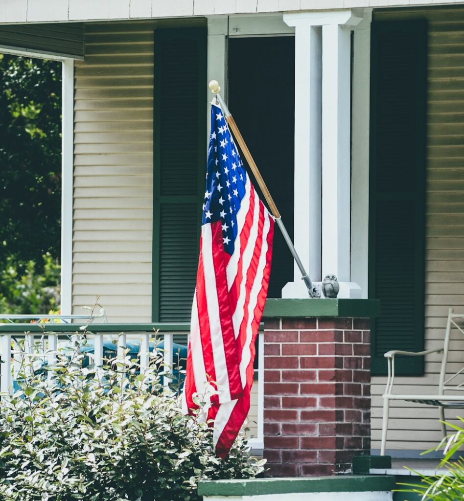 us a flag on white wooden fence